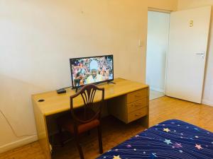 ein Schreibtisch mit einem Computer darauf in einem Schlafzimmer in der Unterkunft Peaceful getaway in Kapstadt