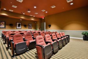 an empty auditorium with red chairs in a room at Touch of Luxury in Kissimmee +36 photos