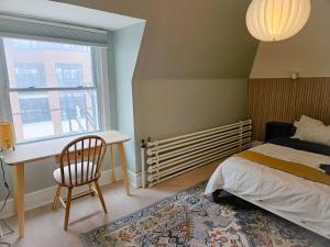 a bedroom with a bed and a desk and a window at Ottawa Downtown Cozy Guesthouse in Ottawa