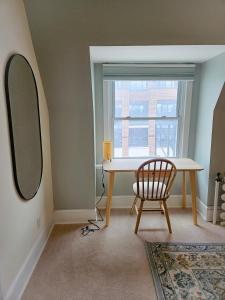 a table and a chair in a room with a window at Ottawa Downtown Cozy Guesthouse in Ottawa