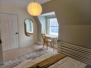 a bedroom with a bed and a desk and a mirror at Ottawa Downtown Cozy Guesthouse in Ottawa