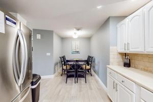 een keuken met een tafel, stoelen en een koelkast bij Rig's Residence in Seminole