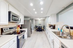 una cucina con mobili bianchi e un lavandino di Rig's Residence a Seminole