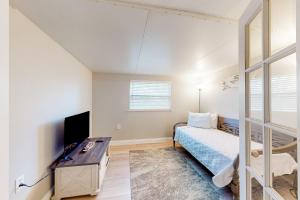 una camera da letto con un letto, una scrivania e una TV di Rig's Residence a Seminole