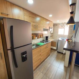 uma cozinha com um frigorífico de aço inoxidável e armários de madeira em VENTURA MADRID em Madrid