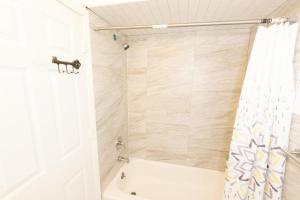 y baño con bañera y cortina de ducha. en Mins from NYC Bright & Spacious 4-Bed Unit, en Jersey City
