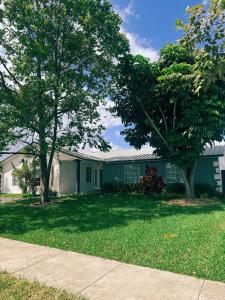 une maison verte avec deux arbres dans la cour dans l'établissement Family Friendly 4Bedroom, 3Bathroom, Hot Tub, BBQ, near Everglades, Miami MetroZoo, à Homestead