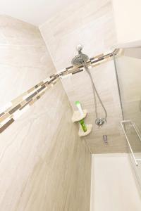 a shower with a hose and a shower head at Bright & Cozy 2-Bed Apt mins to NYC in Jersey City