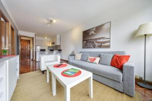 uma sala de estar com um sofá e uma mesa em Apartamento con ascensor, dos habitaciones em La Coruña
