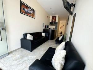 a living room with a black couch and a chair at Las Condes II in Cajamarca