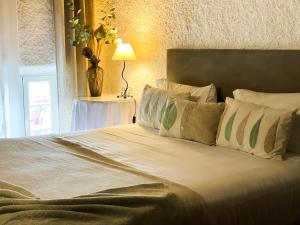 a bedroom with a large bed with pillows and a lamp at Casa de Pilatos in Mosteiros