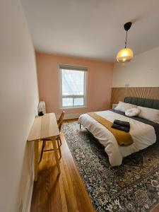 um quarto com uma cama, uma mesa e uma janela em Ottawa Downtown Cozy Guesthouse em Ottawa