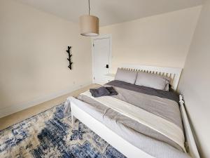a bedroom with a large bed in a white room at Ottawa Downtown Cozy Guesthouse in Ottawa