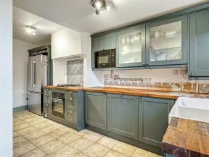 a large kitchen with blue cabinets and a sink at Victoria Cam in Cambridge