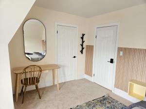 a room with a table and a mirror and a chair at Ottawa Downtown Cozy Guesthouse in Ottawa