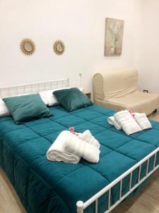 um quarto com uma cama azul com toalhas em Casa kirò em Nápoles