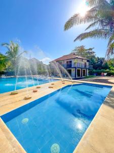 una piscina con 2 fuentes frente a una casa en Villa Effi, en El Porvenir