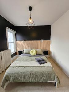 um quarto com uma cama grande e uma parede preta em Ottawa Downtown Cozy Guesthouse em Ottawa