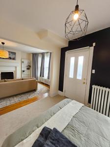 1 dormitorio con 1 cama grande y chimenea en Ottawa Downtown Cozy Guesthouse, en Ottawa