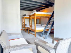 ein Wohnzimmer mit 2 Etagenbetten und Stühlen in der Unterkunft Villa Effi in El Porvenir