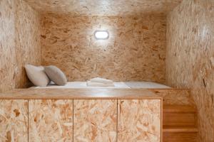 ein kleines Zimmer mit einem Bett in einer Holzwand in der Unterkunft City Hall Apartments in Vila Real