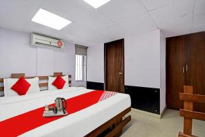 a bedroom with a large bed with red pillows at OYO Flagship Dreamy Sunrise By Stayapart Near City Centre Salt Lake in Kolkata
