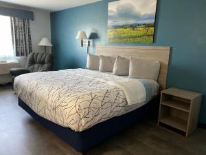 - une chambre avec un lit et un mur bleu dans l'établissement Heritage Inn Express, à Marysville