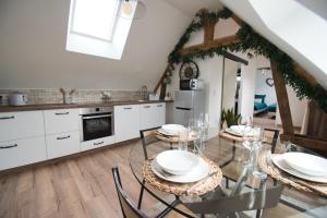 a kitchen with a dining table with white cabinets at LE RELAIS DES CALECHES - l'Appartement "L'aparté" in Broué
