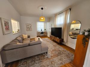 a living room with a couch and a television at Ottawa Downtown Cozy Guesthouse in Ottawa