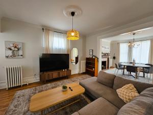 a living room with a couch and a flat screen tv at Ottawa Downtown Cozy Guesthouse in Ottawa
