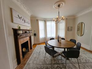 a dining room with a table and a fireplace at Ottawa Downtown Cozy Guesthouse in Ottawa