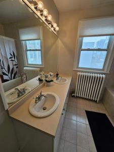 a bathroom with two sinks and a large mirror at Ottawa Downtown Cozy Guesthouse in Ottawa