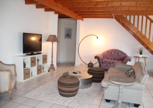 uma sala de estar com um sofá e uma televisão em Ty Traezh - La plage à 100m em Santec