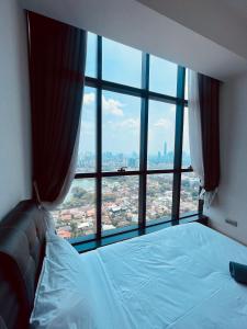 een bed in een kamer met een groot raam bij M City Ampang Apartment by ICONUS in Kuala Lumpur