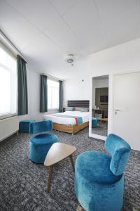 une chambre d'hôtel avec deux chaises et un lit dans l'établissement Grand Hotel de Flandre, à Namur