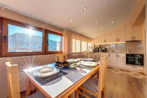 a kitchen with a table with chairs and a tableasteryasteryasteryasteryasteryastery at Apartment Yana- The Amazing View in Smolyan +8 photos
