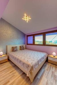 a bedroom with a bed and two windows at Apartment Yana- The Amazing View in Smolyan