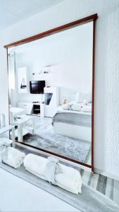 espejo en un dormitorio blanco con cama en Apartment Sekulic, en Doboj