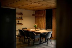 a dining room table with chairs and a vase of flowers on it at Na samotě u lesa - Jeseníky in Mikulovice