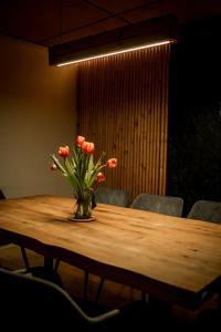 a vase of orange flowers sitting on a wooden table at Na samotě u lesa - Jeseníky in Mikulovice