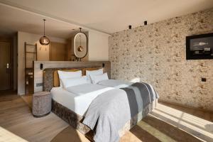 a bedroom with a large bed and a stone wall at Badia Hill in Badia