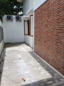 un mur en briques à côté d'un bâtiment avec une porte dans l'établissement HOUSE IN SURAKARTA, à Grogol