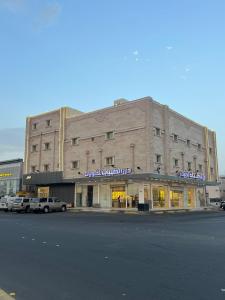 a large building with cars parked in front of it at شقق القارات السبع المخدومة in Medina