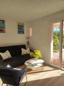 een woonkamer met een bank en een tafel bij Joli appartement avec jardin dans résidence avec piscines in Agay - Saint Raphael