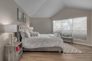Un dormitorio con una cama grande y una ventana en Frisco Spacious & Cozy Bling Home by Aya en Frisco