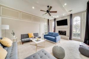 a living room with a blue couch and a fireplace at Stunning Gables House Basketball Court in Dallas