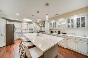 a large kitchen with white cabinets and a large white island at Stunning Gables House Basketball Court in Dallas