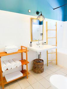 ein Bad mit einem Waschbecken und einem Spiegel in der Unterkunft Case Thérèse in Petit-Bourg