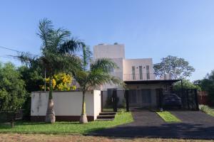 a house with a palm tree in front of it at Habitación con amplia terraza en Encarnacion in Encarnación