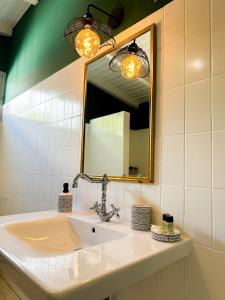 W łazience znajduje się umywalka i lustro. w obiekcie Case Thérèse w mieście Petit-Bourg